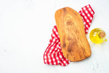 Mutfak masası. Zeytin tahtası, zeytinyağı ve beyaz üzerine masa örtüsü. Kopyalama alanı olan düz.