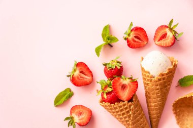 Çilekli dondurma. Dondurma külahı pembe üzerine üst görünüm.