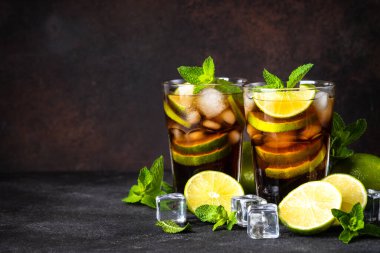 Küba Libre alkollü kokteyli, koyu arkaplanda buzlu içecek..