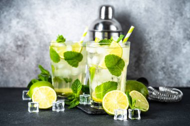 Siyah arka planda rom, nane ve limon ile mojito. Geleneksel yaz içkisi, titretici ve bar aletleriyle..