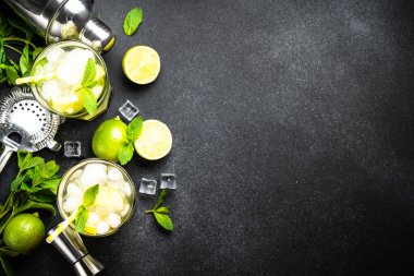 Siyah arka planda rom, limon, nane ve buzlu mojito. Geleneksel yaz içkisi. Kopyalama alanı olan düz.