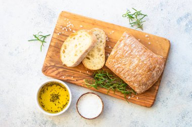 Ciabatta ekmeği ve zeytinyağı. Beyaz masadaki üst görünüm.