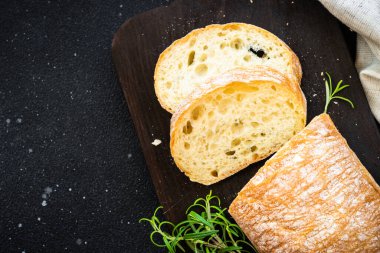 Ciabatta ekmeği tahtada, siyah arka planda. Kopyalama alanı olan üst görünüm.