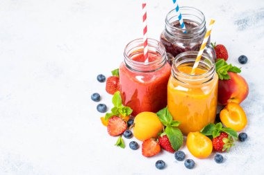 Beyaz arka planda taze meyve ve böğürtlenli meyve püresi. Ev yapımı sağlıklı içecek..