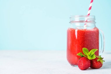Mavi arka planda taze böğürtlenli çilekli smoothie.