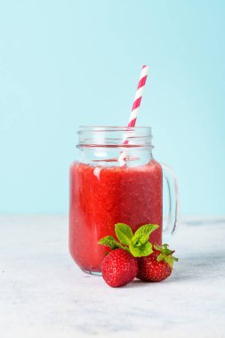 Mavi arka planda taze böğürtlenli çilekli smoothie.