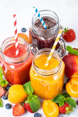 Beyaz arka planda taze meyve ve böğürtlenli meyve püresi. Ev yapımı sağlıklı içecek..