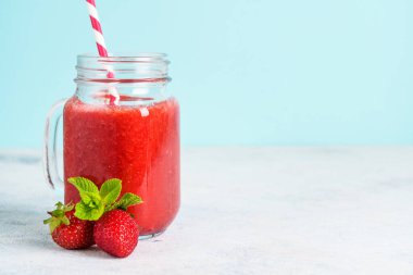 Mavi arka planda taze böğürtlenli çilekli smoothie.