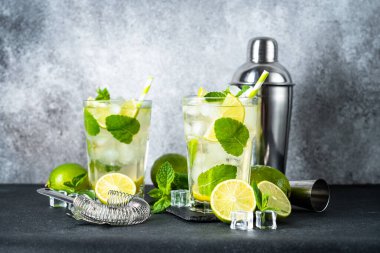 Siyah arka planda rom ve limonlu mojito. Geleneksel buzlu yaz içeceği.