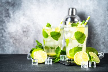 Siyah arka planda rom, nane ve limon ile mojito. Geleneksel yaz içkisi, titretici ve bar aletleriyle..