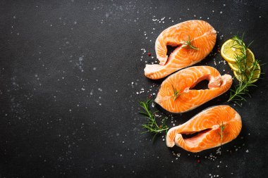 Çiğ balık, siyah arka planda taze somon bifteği..