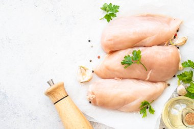 Tavuk fileto, beyaz arka planda baharatlı çiğ tavuk göğsü. Metin için boşluk olan üst görünüm.