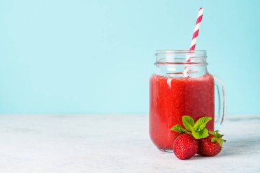 Mavi arka planda taze böğürtlenli çilekli smoothie.