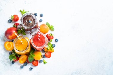 Beyaz arka planda taze meyve ve böğürtlenli meyve püresi. Kavanozda meyve püresi. Kopyalama alanı olan üst görünüm.