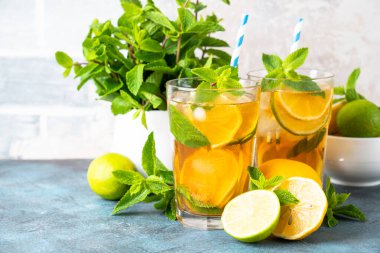 Buzlu çay. Limonlu, limonlu, naneli ve buzlu siyah çay. Soğuk limonata, mutfak masasında yaz içkisi..