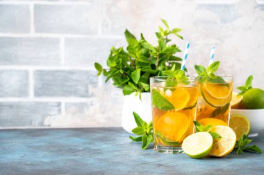 Buzlu çay. Limonlu, limonlu, naneli ve buzlu siyah çay. Soğuk limonata, mutfak masasında yaz içkisi..