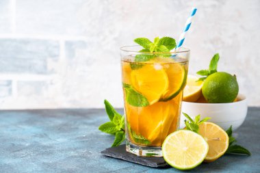 Malzemeli buzlu çay. Limonlu, limonlu, naneli ve buzlu siyah çay. Soğuk limonata, mutfak masasında yaz içkisi..