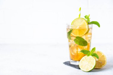 Buzlu çay. Limonlu, limonlu, naneli ve buzlu siyah çay. Soğuk limonata, yaz içkisi, beyaz arka plan..
