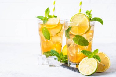 Buzlu çay. Limonlu, limonlu, naneli ve buzlu yaz içeceği. Soğuk limonata, beyaz arka plan.