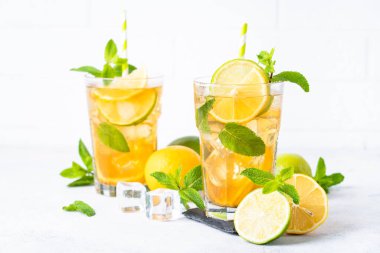 Buzlu çay. Limonlu, limonlu, naneli ve buzlu siyah çay. Soğuk limonata, yaz içkisi, beyaz arka plan..