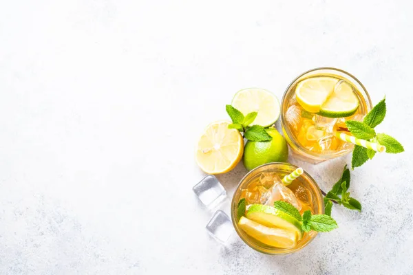 stock image Iced tea. Black tea with lemon, lime, mint and ice. Cold lemonade, summer drink, white background. Top view with copy space.