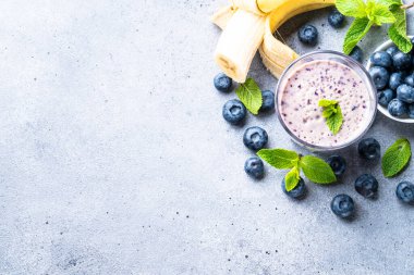 Yaban mersinli muzlu smoothie veya taze meyveli milkshake. Kopyalama alanı olan üst görünüm.