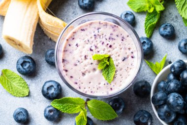 Yaban mersinli muzlu smoothie veya taze meyveli milkshake. Üst görünüm, kapat.