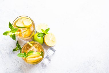 Buzlu çay. Limonlu, limonlu, naneli ve buzlu siyah çay. Soğuk limonata, yaz içkisi, beyaz arka plan. Kopyalama alanı olan üst görünüm.