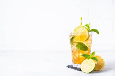 Buzlu çay. Limonlu, limonlu, naneli ve buzlu yaz içeceği. Soğuk limonata, beyaz arka plan.