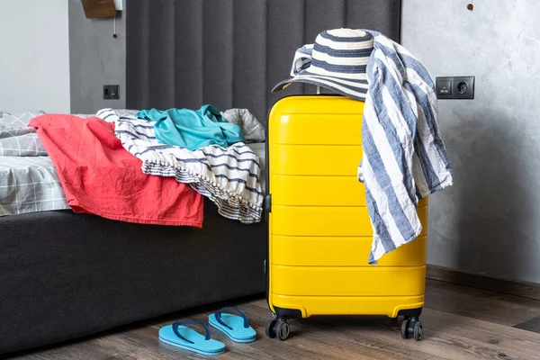 stock image Packing baggage to summer travel in the bedroom. Suitcase with summer cloth and hat.