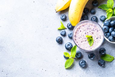 Yaban mersinli muzlu smoothie veya taze meyveli milkshake. Kopyalama alanı olan üst görünüm.