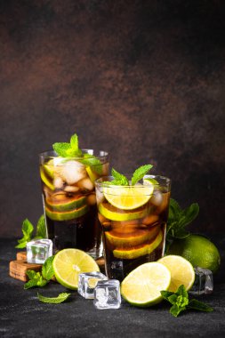 Küba Libre alkollü kokteyli, koyu arkaplanda buzlu içecek..