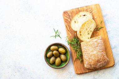 Ciabatta ekmeği ve zeytinyağı. Kopyalama alanı olan beyaz tablo üzerindeki üst görünüm.