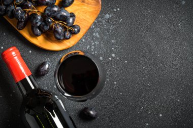 Kırmızı şarap siyah arka planda. Bir bardak şarap, şişe ve krep. Kopyalama alanı olan üst görünüm.