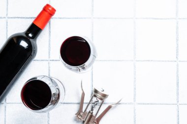 Beyaz arka planda kırmızı şarap. Şarap, şarap şişesi ve sert gölgeli tirbuşon..