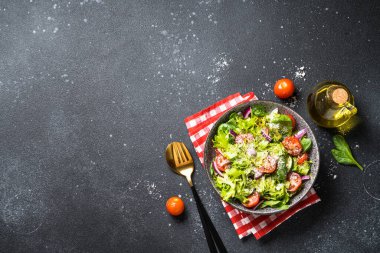 Siyah arka planda taze yapraklı yeşil sebze salatası. Üst görünüm.