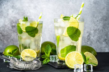 Siyah arka planda rom, limon, nane ve buzlu mojito. Geleneksel yaz içkisi.