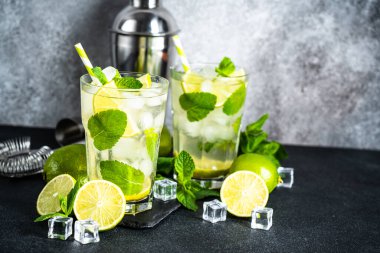 Siyah arka planda rom ve limonlu mojito. Gelenek. Buzlu yaz içkisi..