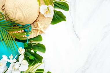 Yaz tatili ve seyahat konsepti. Palmiye yaprakları, beyaz arka planda şapka ve parmak arası terlik. Kopyalama alanı olan düz.