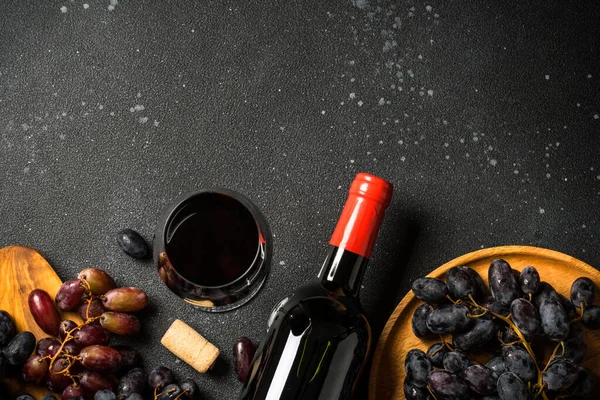 黑色背景的红酒酒杯 酒瓶和葡萄 带有复制空间的顶部视图 — 图库照片