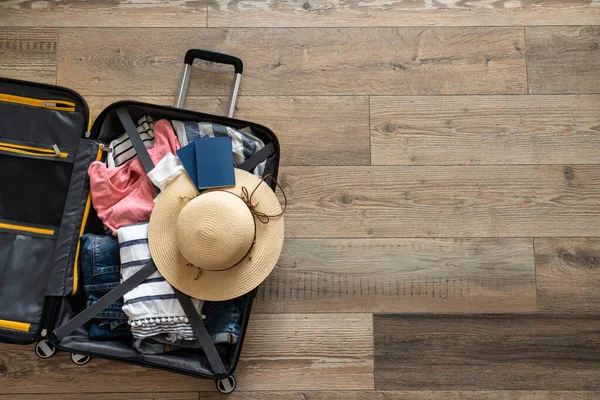 パスポートが付いているスーツケースを開けて下さい 旅行コンセプト 木の背景に平らな層のイメージ — ストック写真