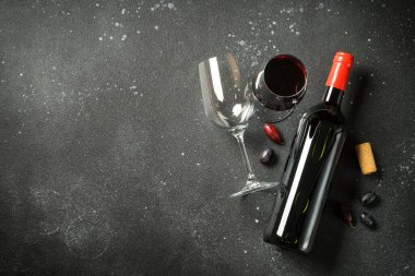 Siyah arka planda şarap şişesi ve şarap kadehi. Kopyalama alanı olan üst görünüm.