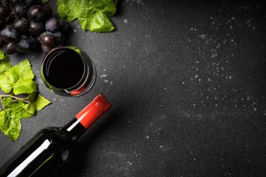 Kırmızı şarap siyah arka planda. Bir bardak şarap, şişe ve taze krep. Kopyalama alanı olan üst görünüm.