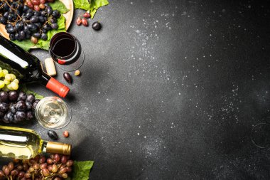 Şarap seti siyah arka planda. Beyaz ve kırmızı şarap, bir kadeh şarap, şişe ve taze krep. Kopyalama alanı olan üst görünüm.