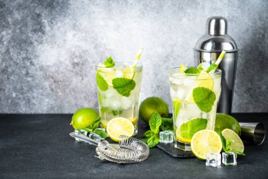 Siyah arka planda rom, nane ve limon ile mojito. Geleneksel yaz içkisi, titretici ve bar aletleriyle..