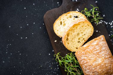 Ciabatta ekmeği tahtada, siyah arka planda. Kopyalama alanı olan üst görünüm.