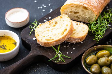 Tahtada ciabatta ekmeği, zeytin yağı, zeytin yağı ve siyah otlar. Akdeniz yemekleri.