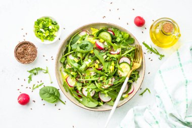 Ispanaklı yeşil salata, roka ve zeytinyağlı turp. Beyaz üzerine üst görünüm.