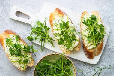 Krem peynirli tost ve mikro yeşillik. Sağlıklı yiyecekler, vejetaryenler, doğal vitaminler. Üst görünüm.