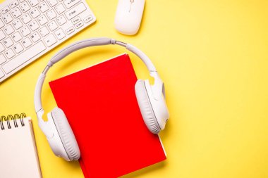 Audio books concept. Headphones and books at yellow background. Listen, study, podcast.